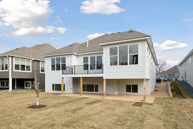 rear view of house featuring a yard and a balcony