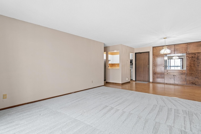 unfurnished living room featuring light hardwood / wood-style flooring and a notable chandelier