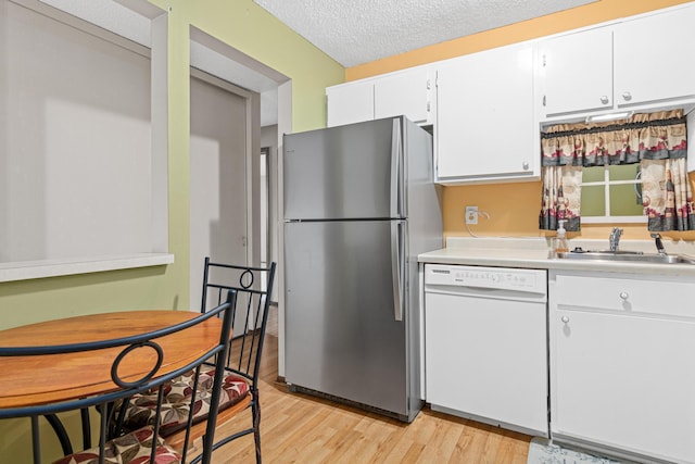 kitchen featuring stainless steel fridge, a textured ceiling, white dishwasher, light hardwood / wood-style flooring, and white cabinetry