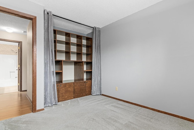 unfurnished bedroom featuring light colored carpet and a textured ceiling