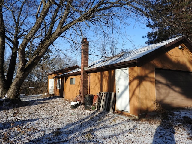 view of snow covered exterior featuring a garage