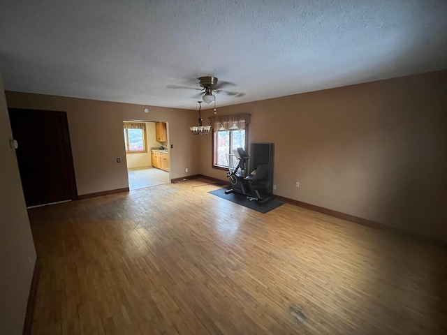 unfurnished room with ceiling fan, a textured ceiling, and light hardwood / wood-style flooring