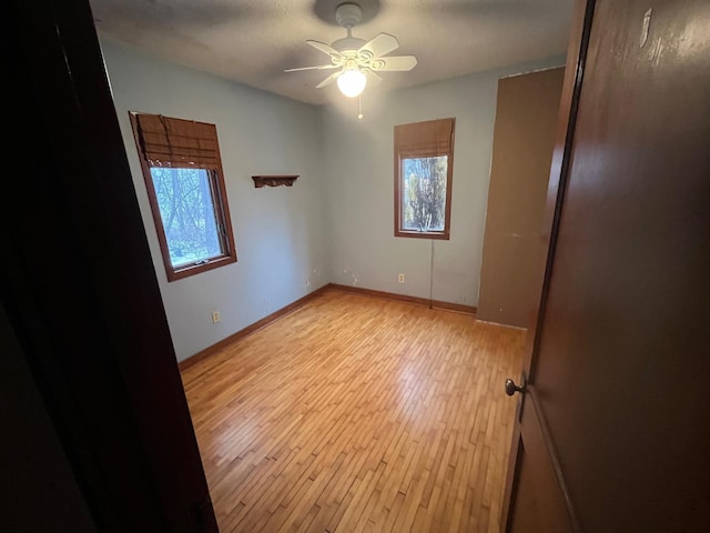 unfurnished room featuring ceiling fan, plenty of natural light, and light hardwood / wood-style floors