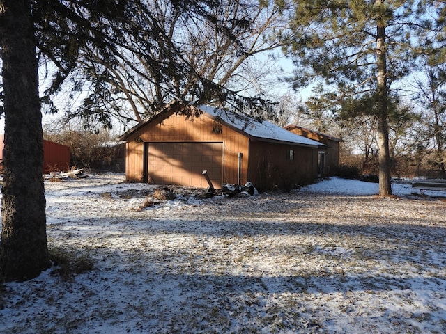 snow covered property featuring a garage