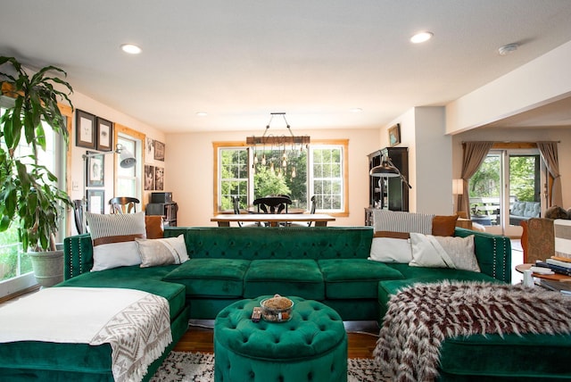 living room with hardwood / wood-style floors, a notable chandelier, and a wealth of natural light