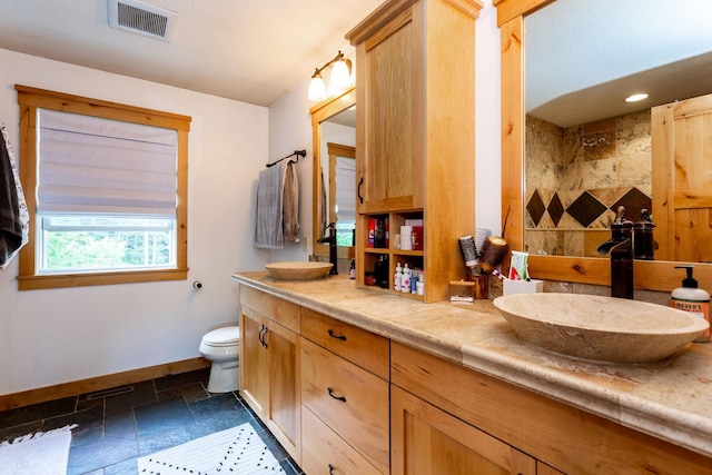 bathroom with walk in shower, vanity, and toilet