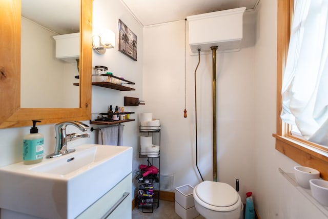 bathroom with vanity, a healthy amount of sunlight, and toilet