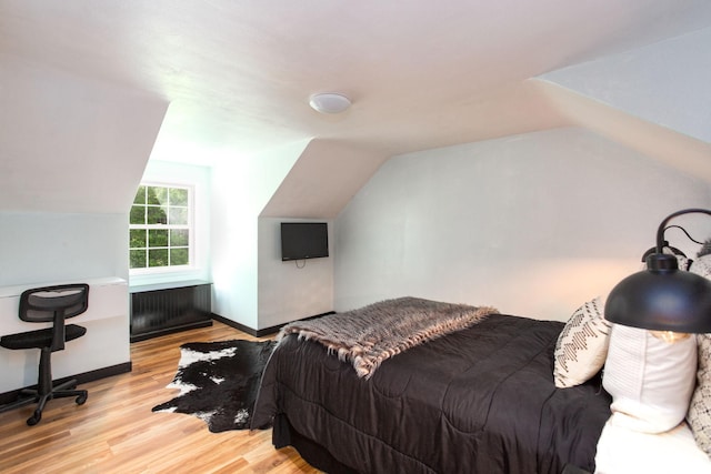 bedroom featuring light hardwood / wood-style floors and vaulted ceiling