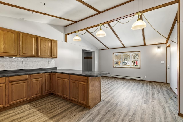 kitchen featuring a baseboard radiator, hanging light fixtures, kitchen peninsula, lofted ceiling, and decorative backsplash