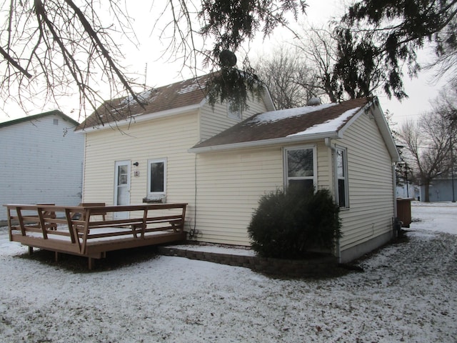 snow covered rear of property featuring a wooden deck