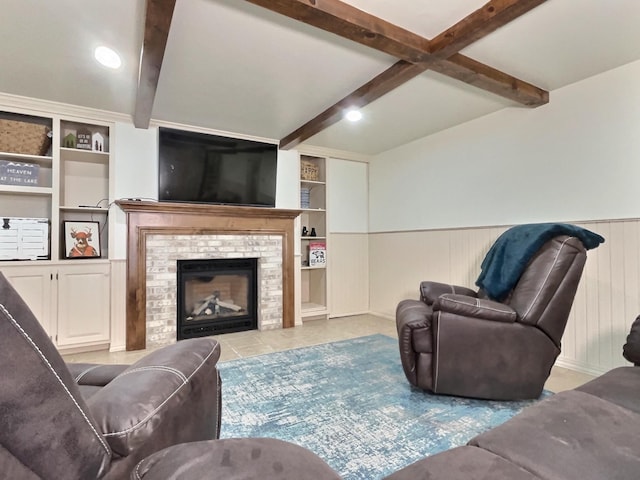 living room with beamed ceiling, built in features, a fireplace, and wooden walls