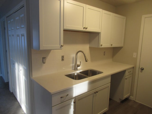 kitchen featuring tasteful backsplash, sink, white cabinets, and dark wood-type flooring