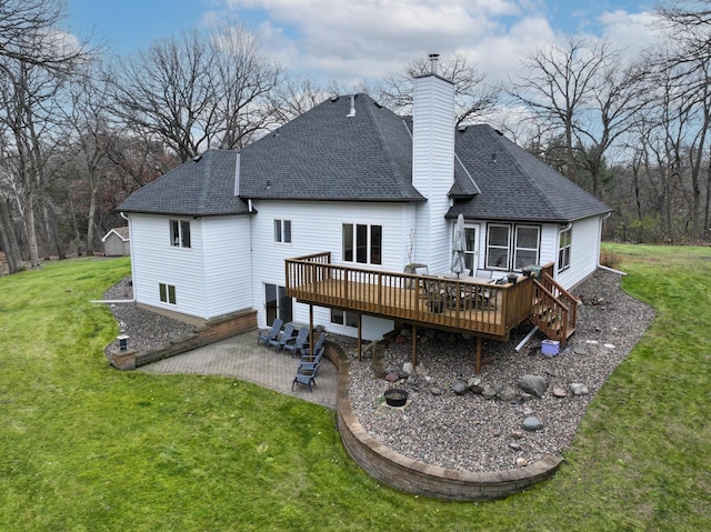 rear view of house featuring a lawn, a wooden deck, and a patio