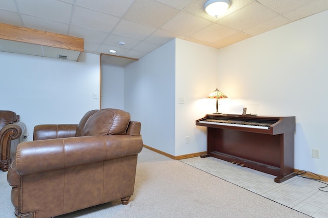 sitting room featuring a paneled ceiling and light colored carpet