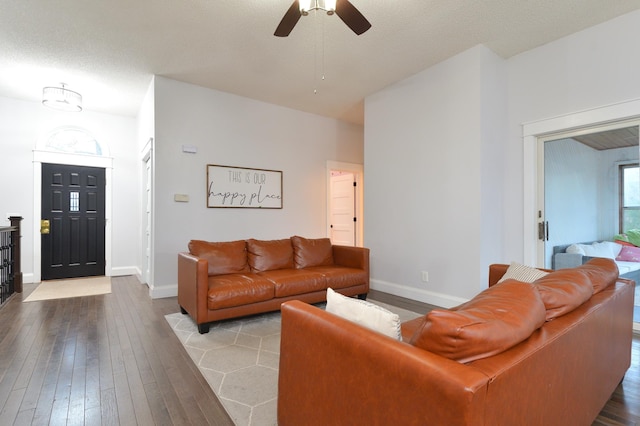 living room featuring ceiling fan, a textured ceiling, and light wood-type flooring