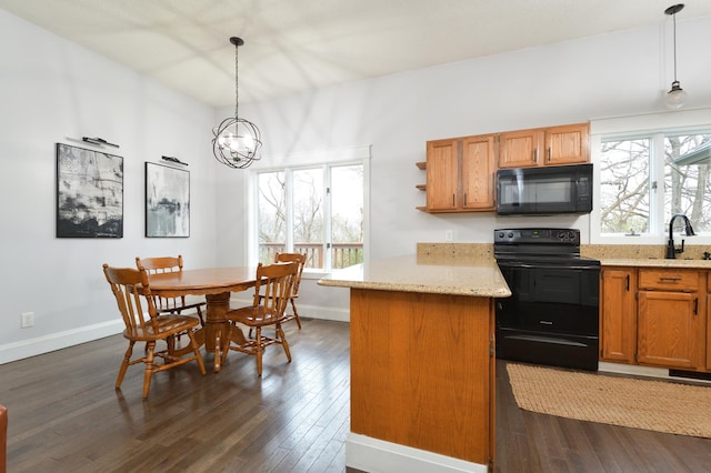 kitchen with black appliances, sink, hanging light fixtures, dark hardwood / wood-style flooring, and light stone counters