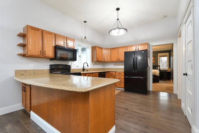 kitchen featuring kitchen peninsula, hanging light fixtures, dark wood-type flooring, and black appliances