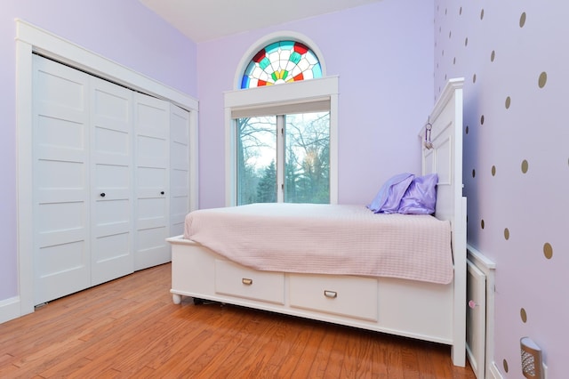 bedroom with light wood-type flooring and a closet