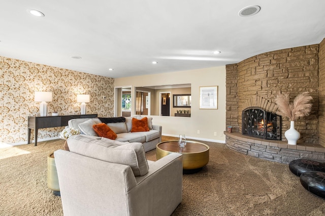 carpeted living room featuring a stone fireplace, recessed lighting, and baseboards