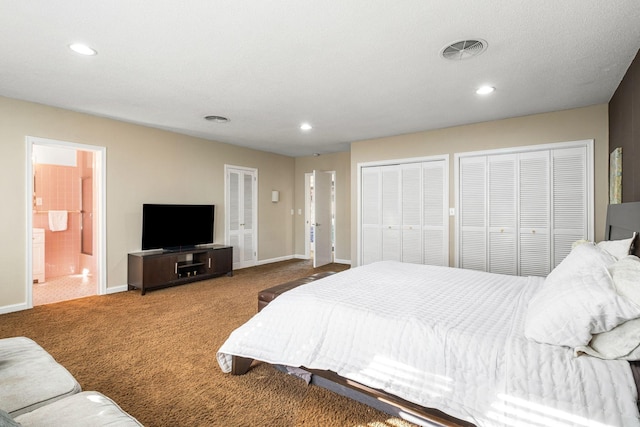 bedroom featuring visible vents, baseboards, two closets, and carpet flooring