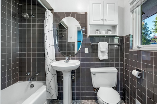 full bathroom featuring a sink, shower / bathtub combination with curtain, toilet, and tile walls