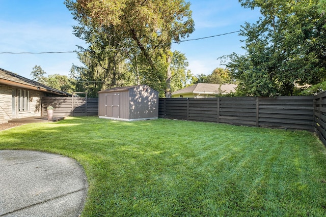 view of yard with an outbuilding, a storage shed, and a fenced backyard