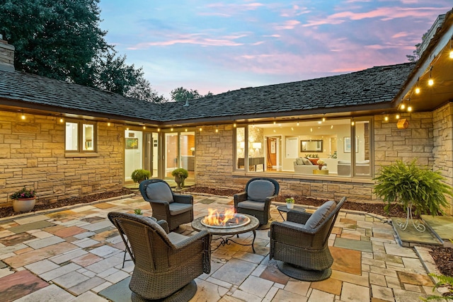 patio terrace at dusk featuring a fire pit