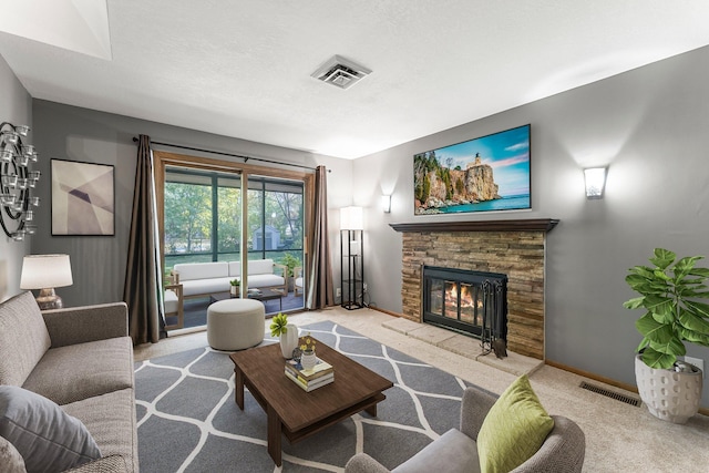 living room with a stone fireplace and carpet floors