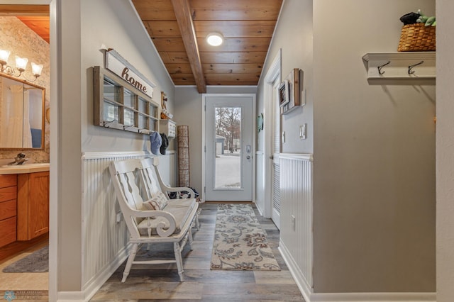 entryway with wood-type flooring, lofted ceiling with beams, and wood ceiling