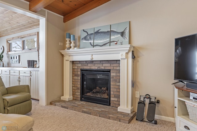 carpeted living room with beamed ceiling, wooden ceiling, and a brick fireplace