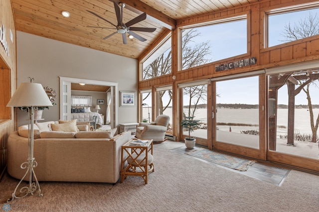 carpeted living room with wood ceiling, ceiling fan, beam ceiling, a water view, and high vaulted ceiling