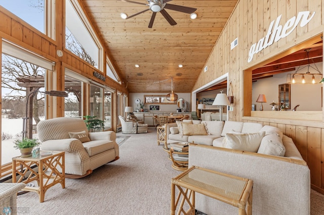 carpeted living room with wooden walls, high vaulted ceiling, ceiling fan, and wooden ceiling