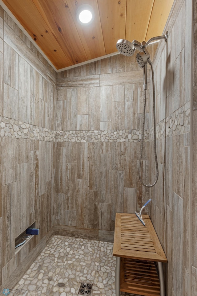 bathroom featuring a tile shower and wooden ceiling