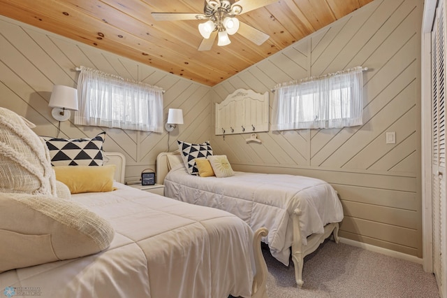 carpeted bedroom with lofted ceiling, ceiling fan, wooden ceiling, and wooden walls