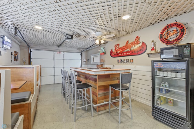 garage featuring black fridge and ceiling fan