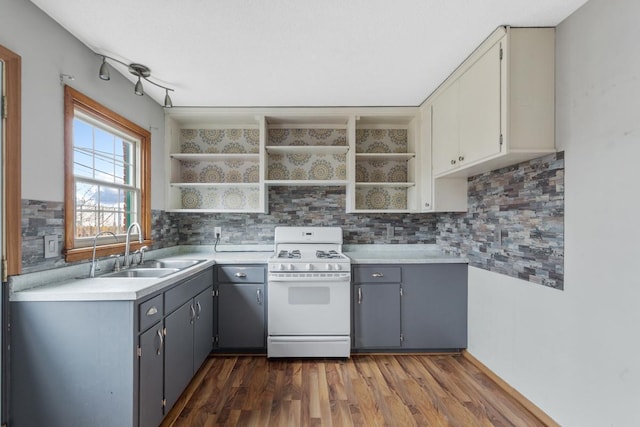 kitchen with gray cabinetry, sink, dark wood-type flooring, tasteful backsplash, and white gas range oven