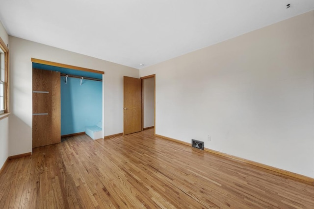 unfurnished bedroom featuring light hardwood / wood-style floors and a closet