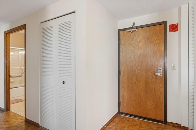 hallway featuring a textured ceiling and parquet flooring