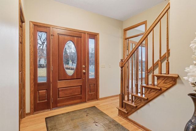 entryway featuring stairs, wood finished floors, and baseboards