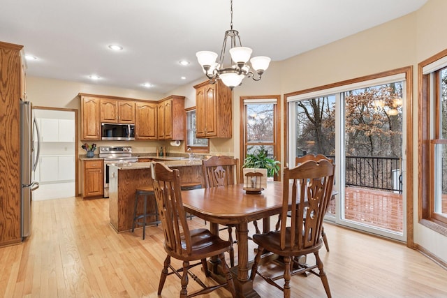 dining room featuring a notable chandelier, recessed lighting, baseboards, and light wood finished floors