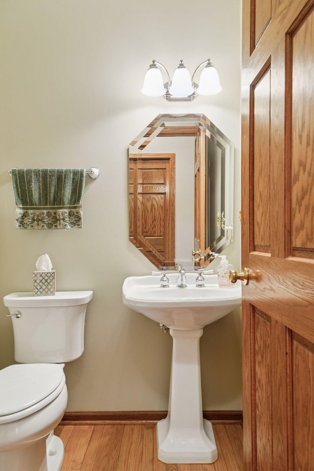 bathroom featuring baseboards, toilet, and wood finished floors