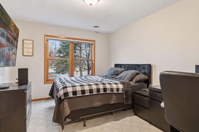 bedroom with a textured ceiling, baseboards, visible vents, and light carpet