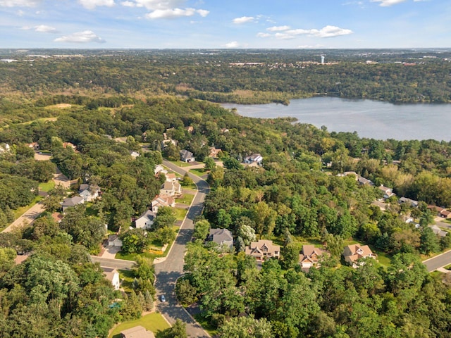 birds eye view of property with a wooded view and a water view