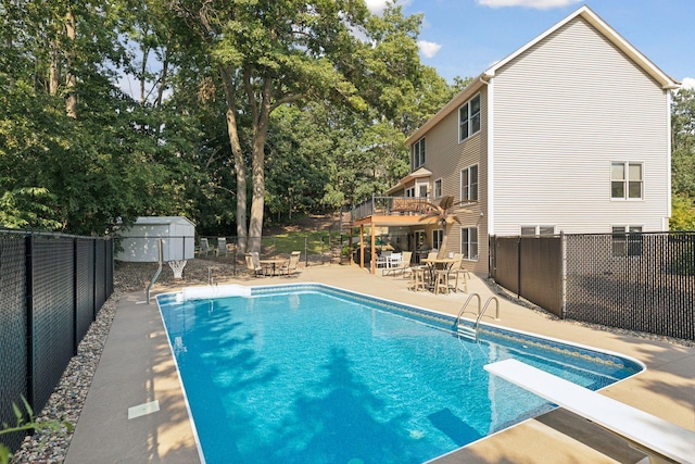 view of pool with a patio area, a fenced in pool, a fenced backyard, and a diving board