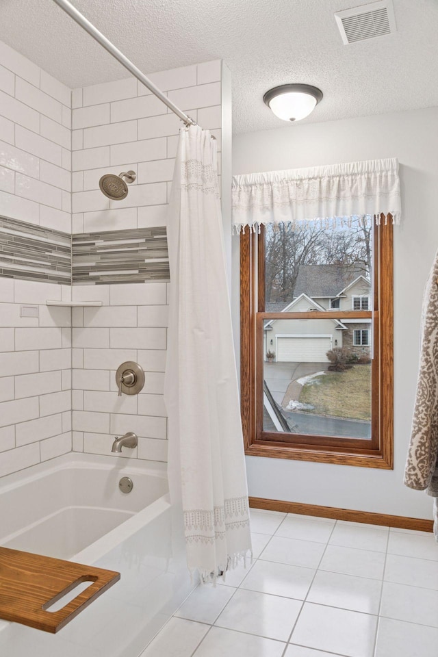 full bathroom with tile patterned floors, visible vents, a textured ceiling, shower / tub combo, and baseboards