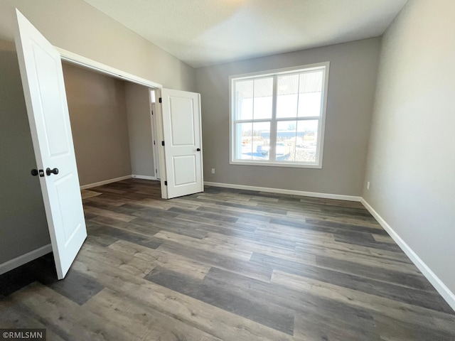 unfurnished bedroom with dark hardwood / wood-style flooring