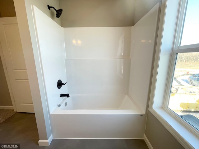 bathroom featuring plenty of natural light and washtub / shower combination