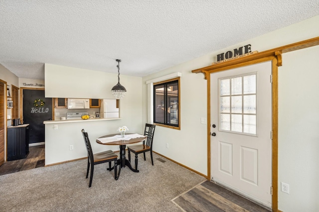 dining space featuring dark colored carpet and a textured ceiling