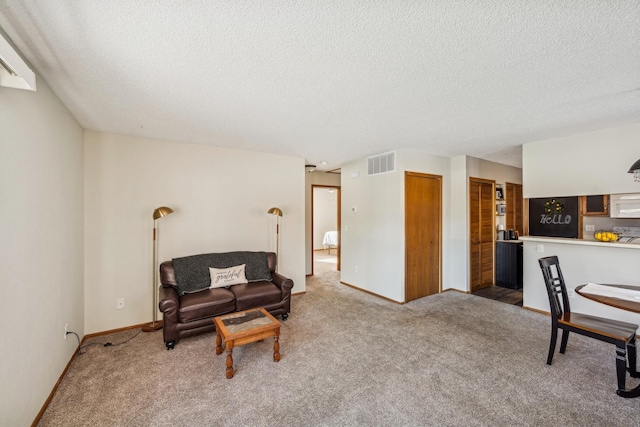 carpeted living room featuring a textured ceiling