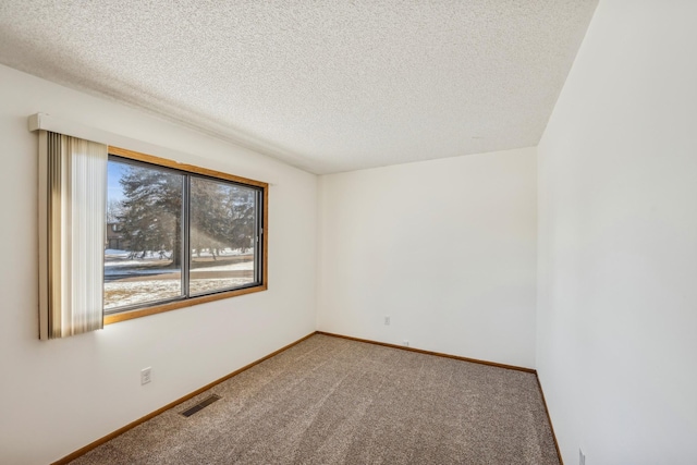 carpeted empty room featuring a textured ceiling